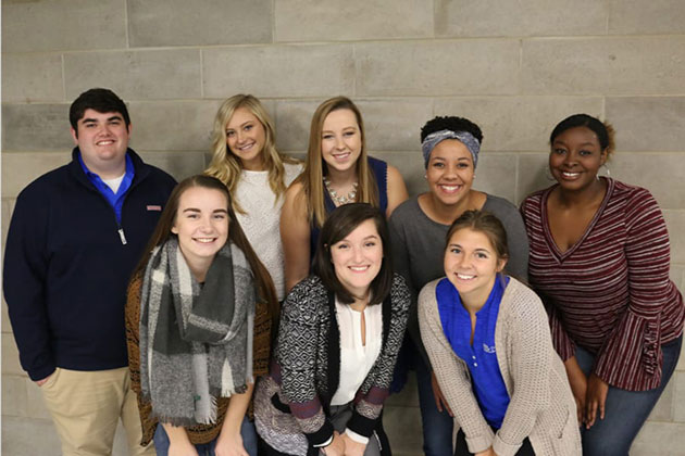 COSW students standing by brick wall