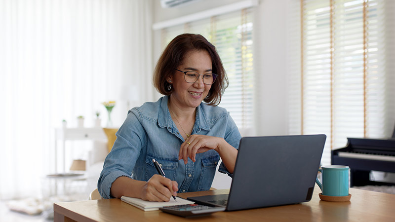 social worker at laptop on kitchen table working from home